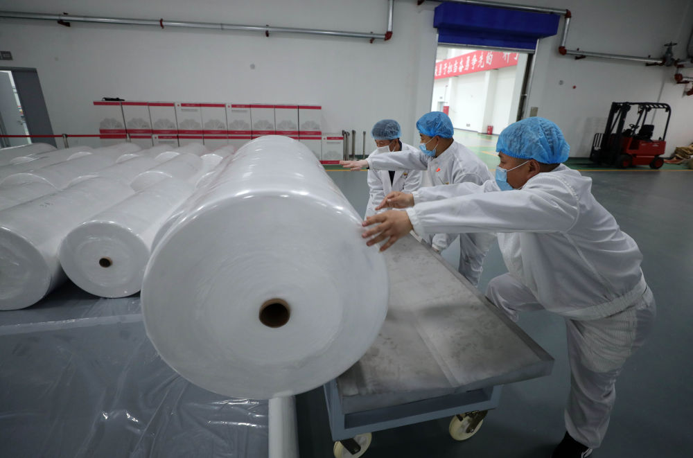 在中国石油辽阳石化公司聚酯厂车间，工人运送刚生产完的熔喷无纺布（4月20日摄）。新华社记者 杨青 摄