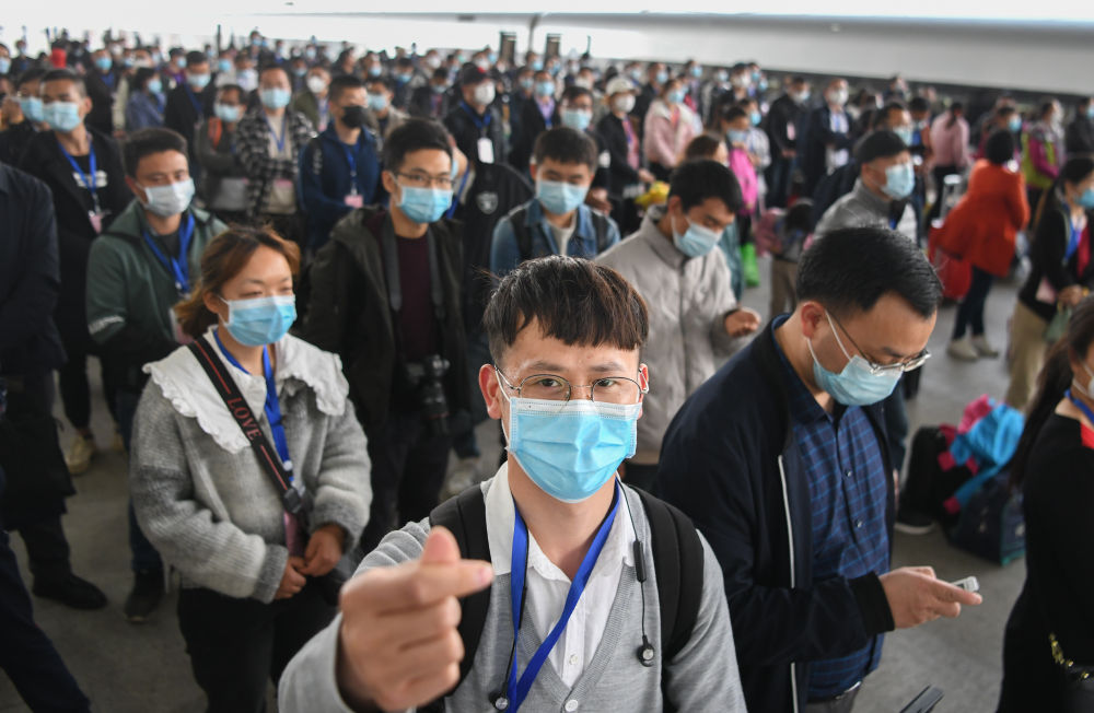 3月19日，在湖北荆州火车站，务工人员陈安心（前）准备上车。当日，551名荆州务工人员搭乘G4368专列抵达广州，返岗就业。新华社记者 程敏 摄